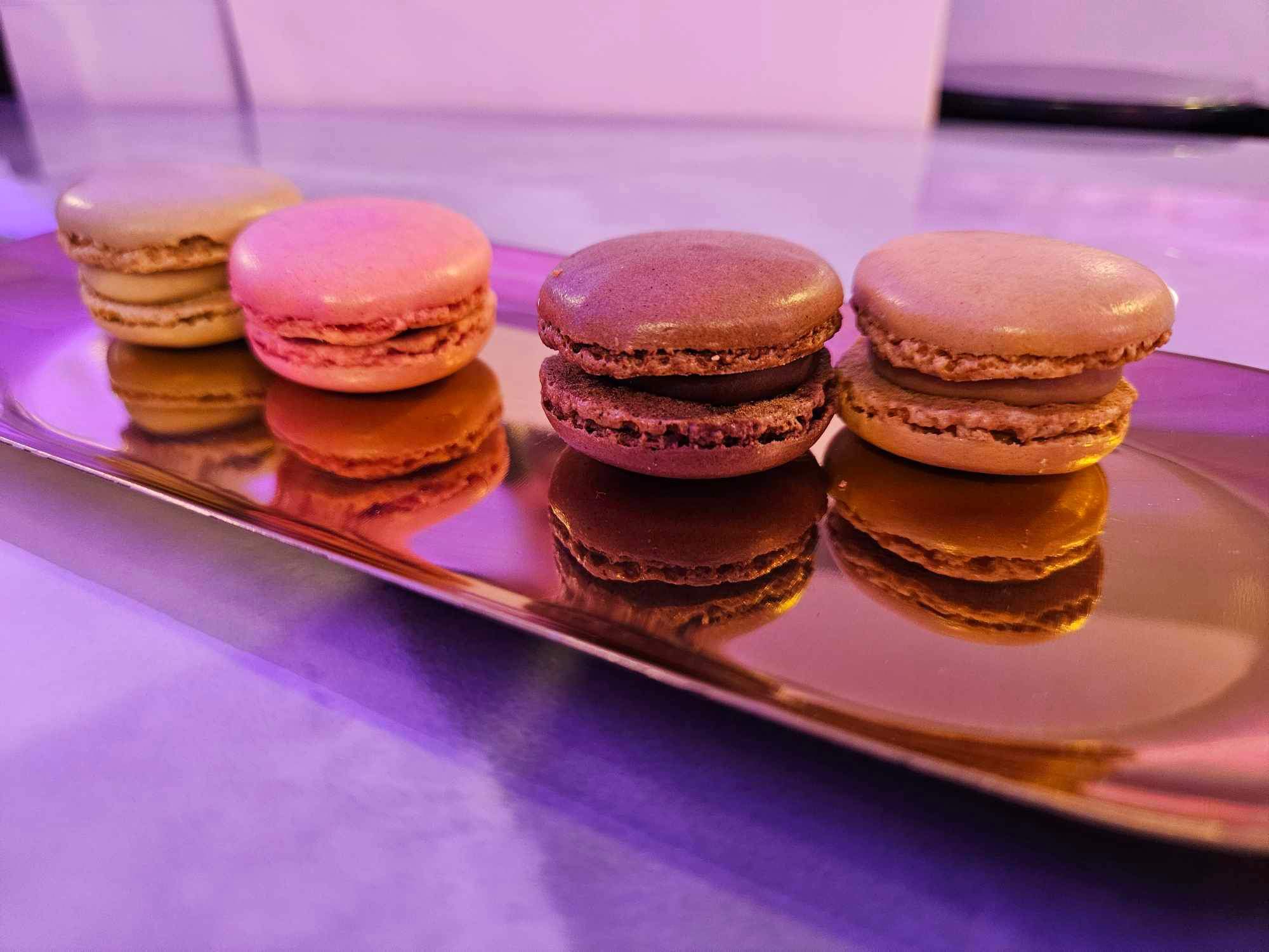 an assortment of macarons on a gold serving platter